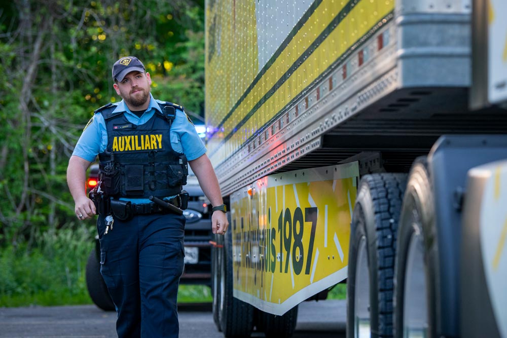 Auxiliary officer inspecting commercial vehicle