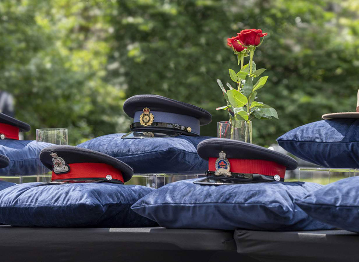 Police hats and flowers at suicide memorial ceremony